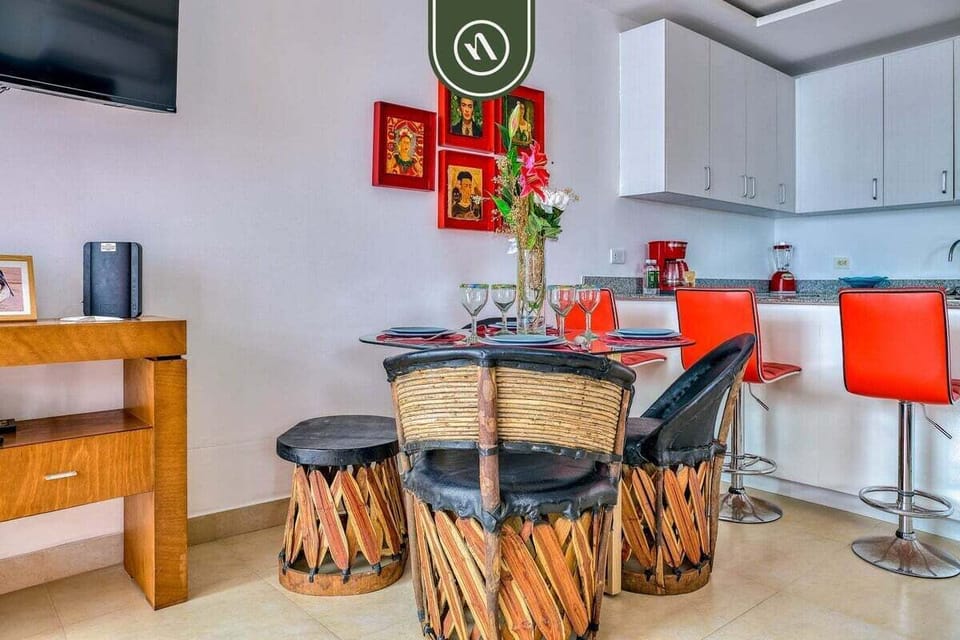 Gather for meals around the glass table featuring authentic Mexican equipal chairs. The bright, open space connects seamlessly to the modern kitchen for easy entertaining.
