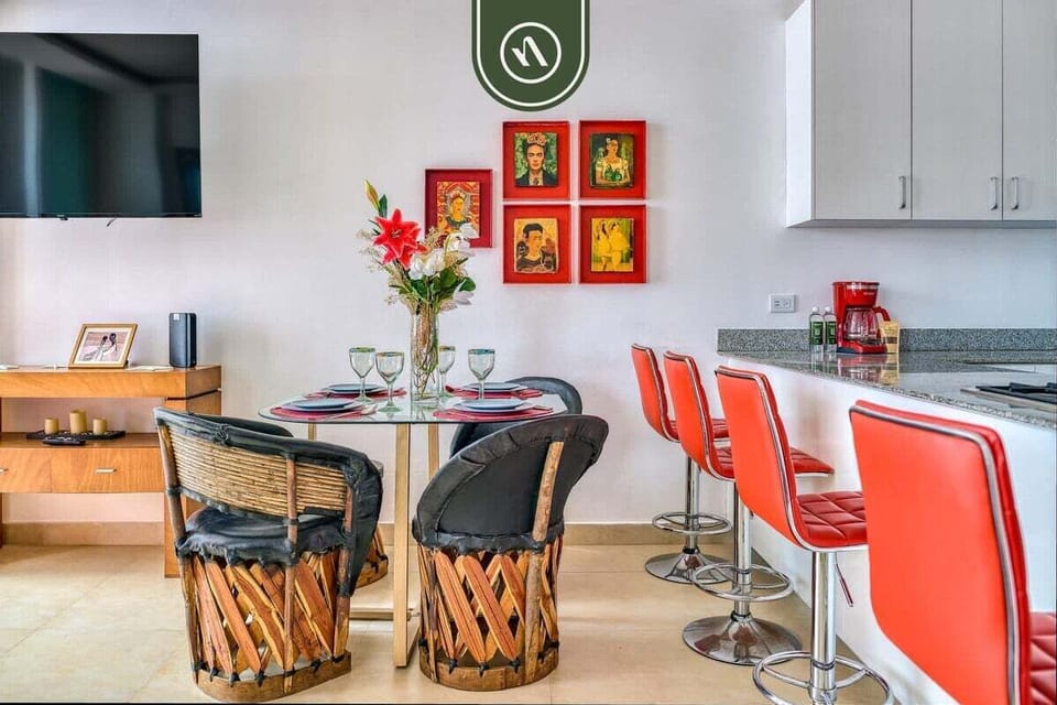 Gather around the table featuring traditional Mexican "equipal" chairs, or grab a quick bite at the breakfast bar. Colorful local art brings this open space to life.