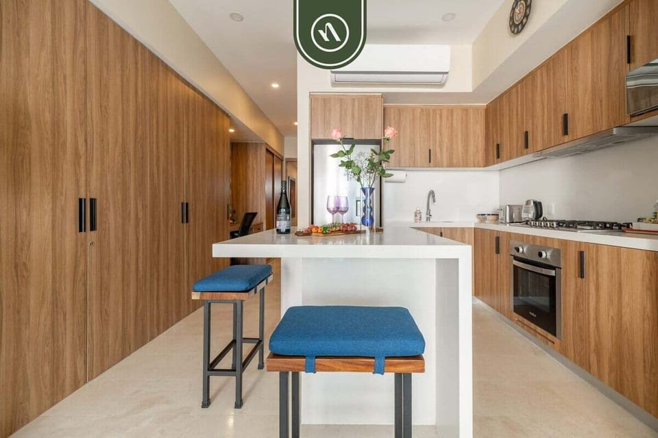 A sleek, modern kitchen with full-size appliances, ample counter space, and bar seating perfect for preparing meals, snacks, or enjoying breakfast before a day at the beach.