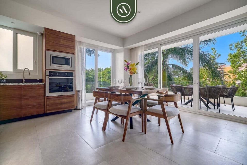 Gather for meals at this chic dining table with seating for six, perfectly framed by large sliding doors looking out onto a palm-lined terrace.