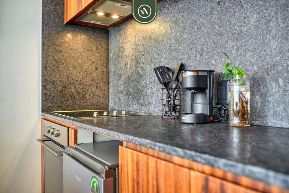 Prepare simple meals and your morning brew in this stylish kitchenette. It features a sleek stone backsplash, a two-burner stove, a mini-fridge, and a coffee maker.