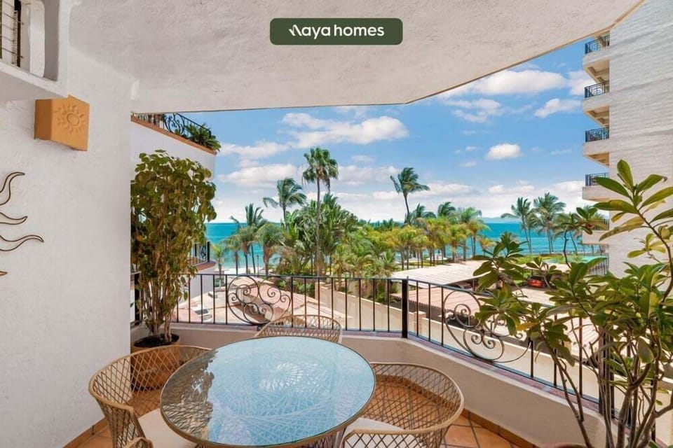 An alternate look at the private covered balcony space, framed by lush green foliage and stunning ocean views.