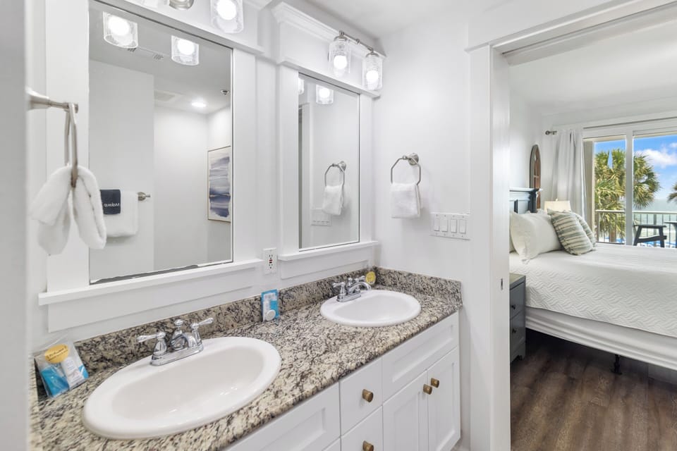 Freshen up in your bright, modern bathroom with dual sinks and granite countertops, perfectly positioned between your bedroom and stunning ocean views just steps away.