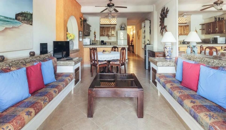 Linear perspective across the cozy open living space showing parallel patterned couches and the dining arrangement beyond.