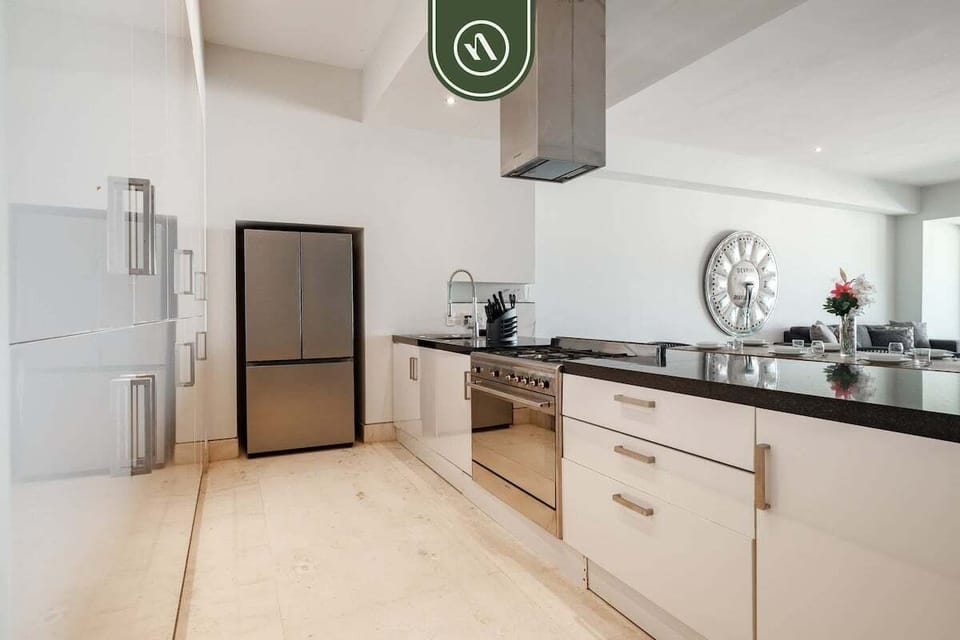 Bright chef-style kitchen with sleek black stone counters, premium appliances, and an open-concept layout designed for effortless entertaining and vacation living.