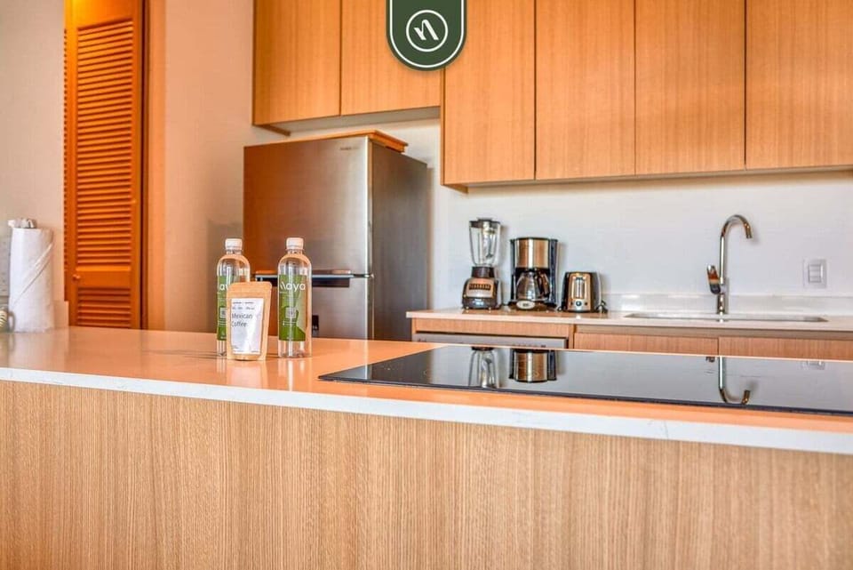 A sleek, fully equipped kitchen featuring stainless steel appliances, premium wood cabinetry, and a spacious breakfast bar perfect for morning coffee.