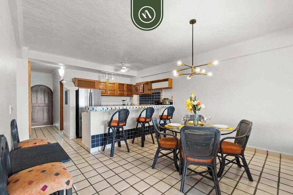 Full view of the dining table seamlessly integrated with the classic tiled kitchen and its wooden cabinetry breakfast bar.
