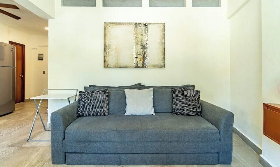 Comfortable gray fabric couch accented with patterned pillows beneath abstract wall art.