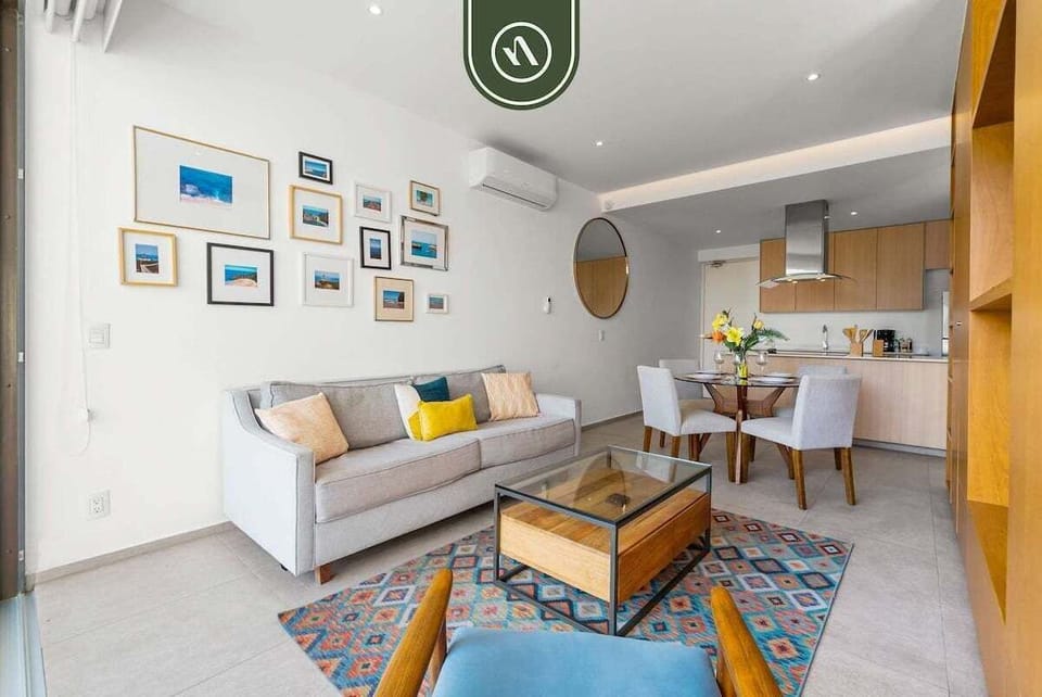 A stylish living and dining space featuring a gallery wall, plush seating, and a sleek kitchenette, perfect for a modern urban lifestyle.