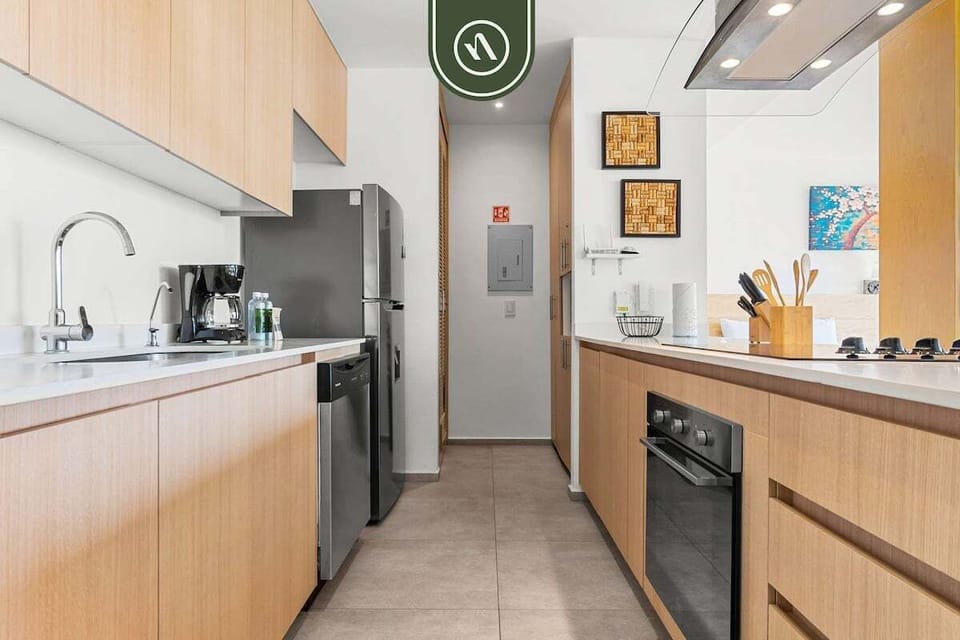 A fully equipped, contemporary kitchen with stainless steel appliances and light wood cabinetry, providing everything needed for a convenient and home-like stay.