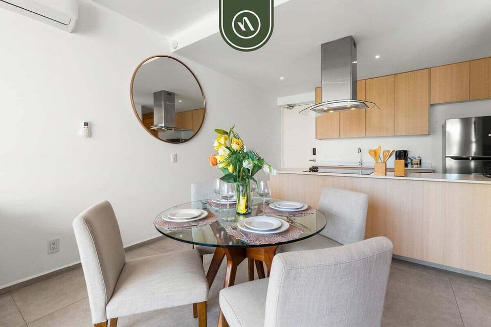 A clean, contemporary kitchen area featuring high-end stainless steel appliances and light wood finishes. This open layout ensures you never miss out on the conversation.