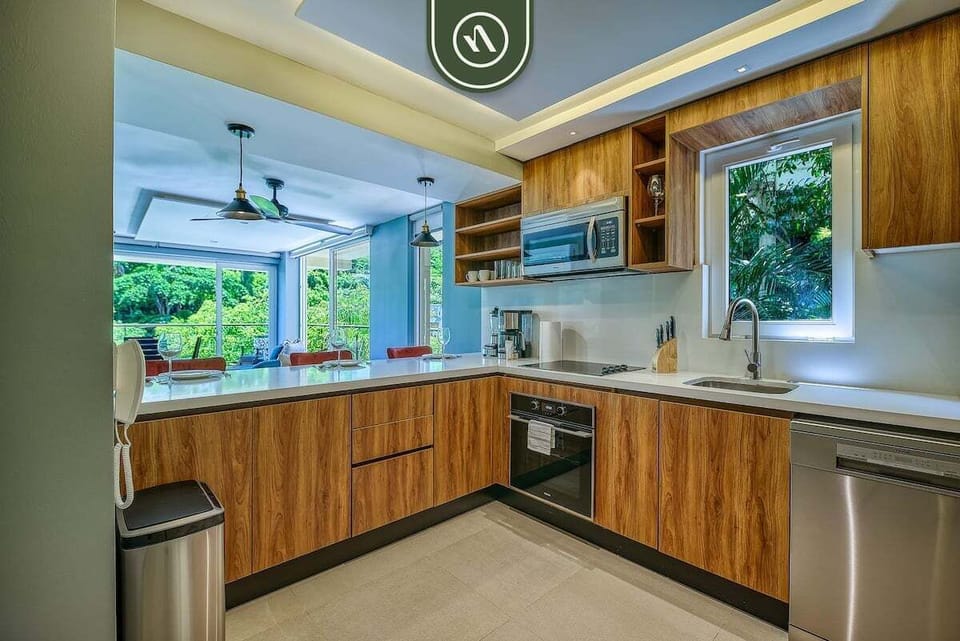 Fully equipped kitchen with custom wood cabinetry, sleek countertops, and modern appliances—perfect for cooking and gathering.