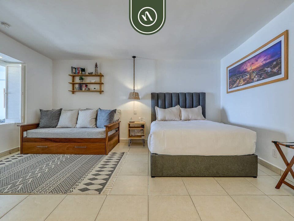 Open perspective of the studio suite showing both the daybed and the main bed.