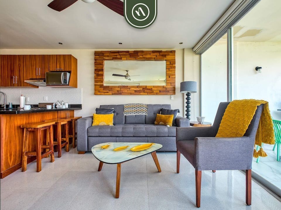 Bright and inviting living space with a fully equipped kitchen, comfortable seating, and seamless indoor-outdoor living, perfect for relaxing and entertaining.