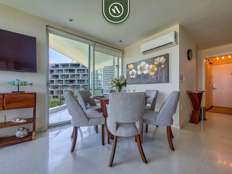 Gather around the dining table surrounded by floor-to-ceiling windows and natural light. A welcoming space for meals, conversation, and quality time together.