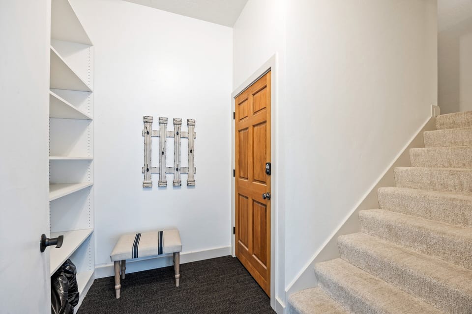 - Entryway with built in shelving and coat hooks for easy organization  
- Comfortable bench provides a spot to remove shoes after adventures  
- Neutral tones and clean design welcome guests into the mountain home