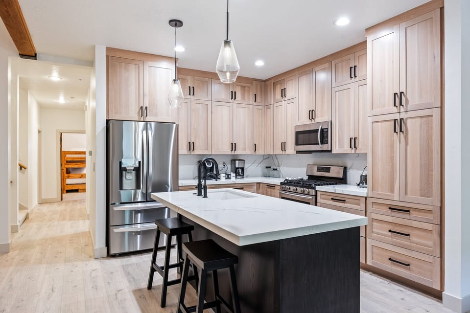 - Modern kitchen with stainless steel appliances and sleek countertops  
- Large center island with seating for casual dining and conversation  
- Abundant cabinet storage and open design ideal for group meal prep