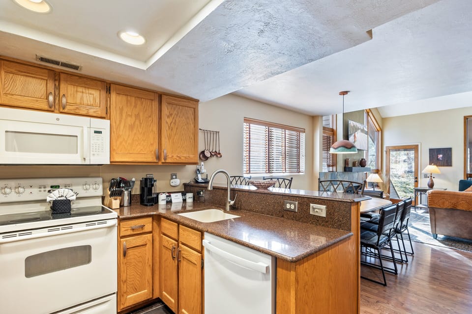 Warm and functional kitchen featuring full-size appliances, ample counter space, and all the essentials for preparing meals after a day on the mountain.