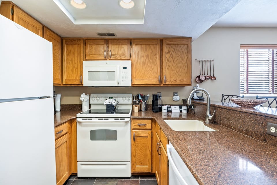 A well-stocked kitchen offering everything needed for home-cooked meals, including full-size appliances, abundant cabinet storage, cookware, and a spacious layout that makes meal prep easy.