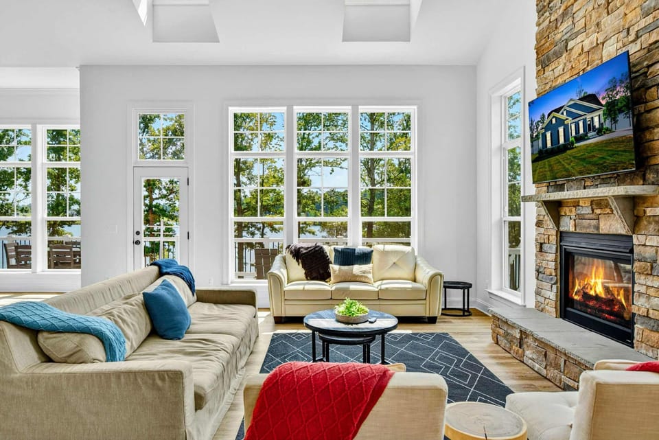 Great Room - Two-story ceilings, a floor-to-ceiling stone fireplace, gas fire, and a Smart TV anchor the heart of the home.