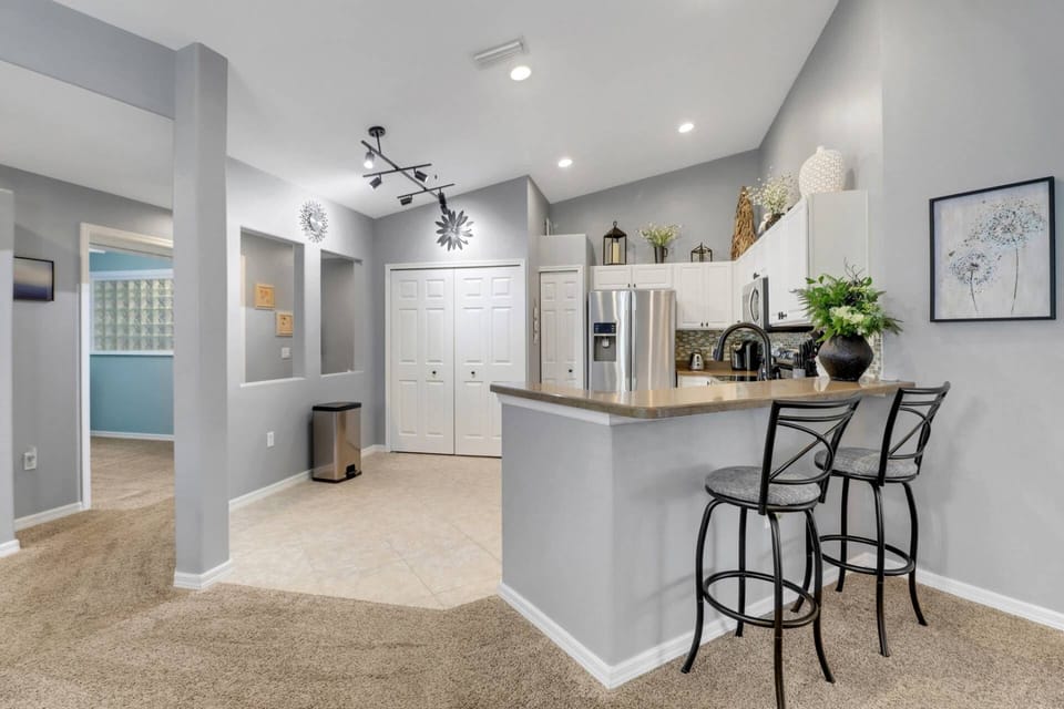 A pair of barstools sit at the eating counter that defines the kitchen space.
