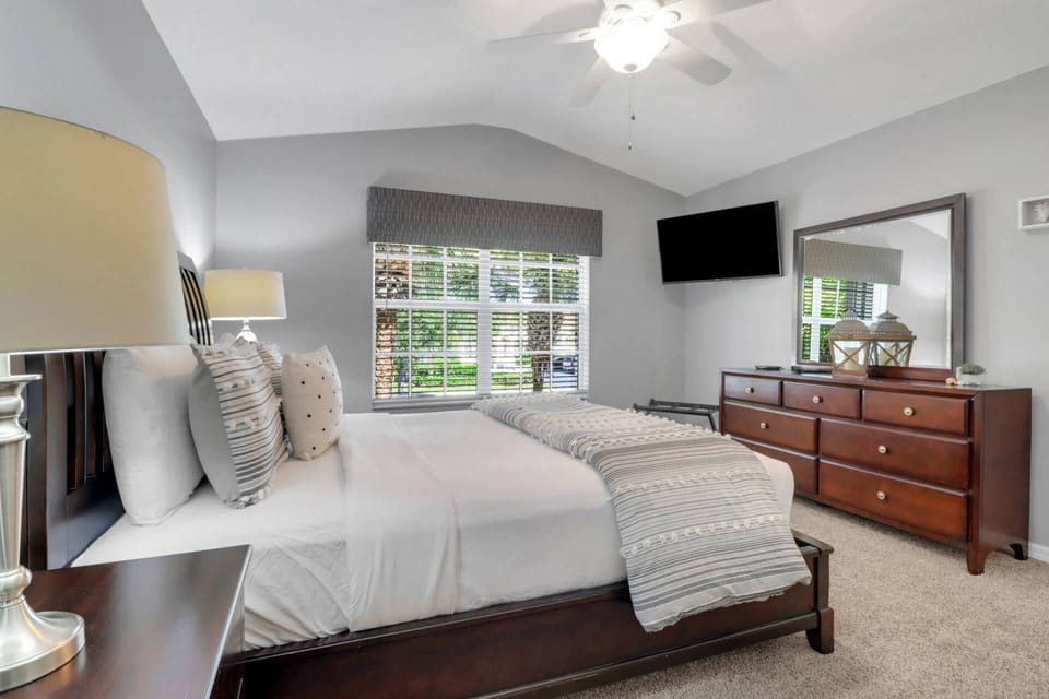 The guest bedroom has a wall-mounted TV with Xfinity cable.
