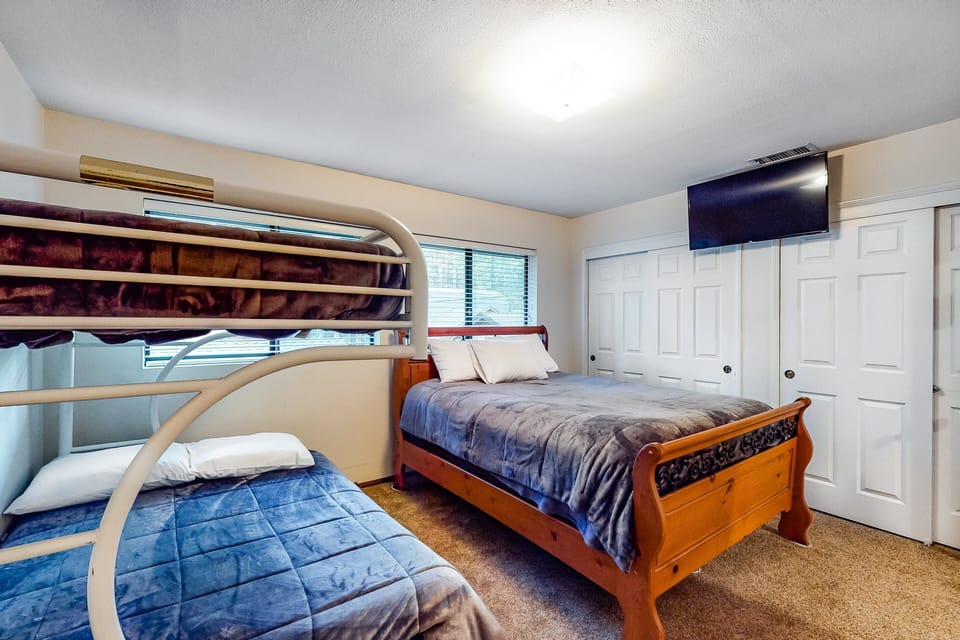 Spacious room featuring a queen bed plus bunk bed, modern style, and comfort.