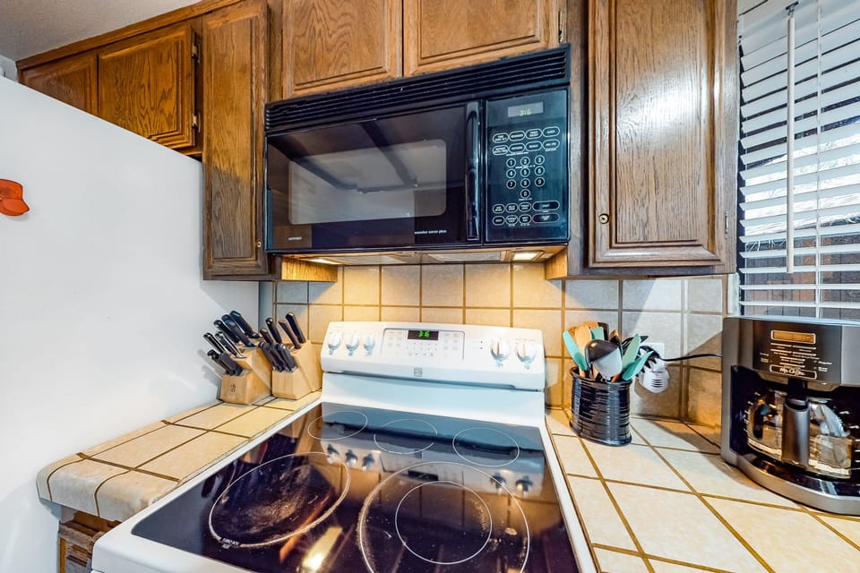 Modern kitchen with sleek counters, bright lighting, and stainless steel.