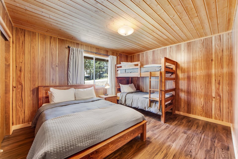 Spacious room featuring a queen bed plus bunk bed, modern style, and comfort.