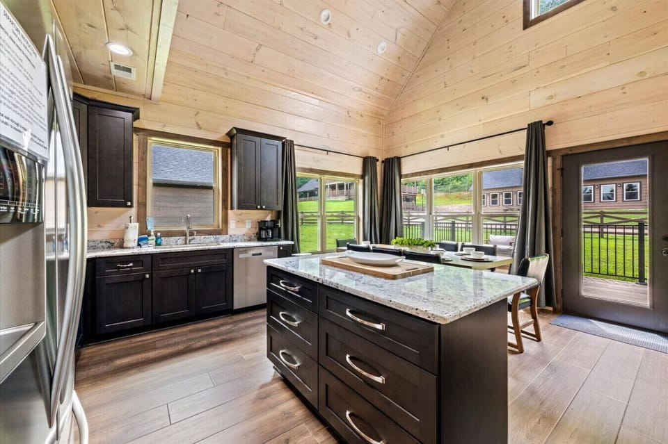 The spacious island offers extra prep space and storage, while oversized windows brighten the kitchen with natural light and views of the outdoors.