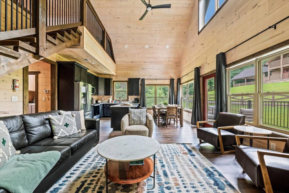 Natural light pours in through large windows, highlighting the mix of rustic charm and modern comfort, making this the perfect gathering place for family and friends.