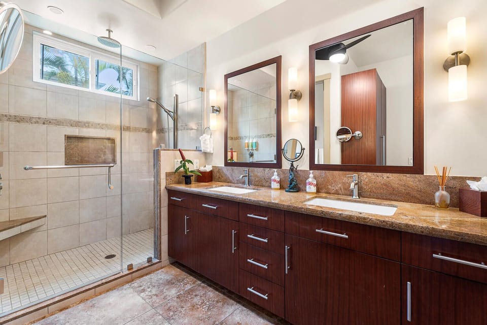 Travertine tile, rainfall glass shower, and twin sinks mean no one has to wait before the dinner reservation downtown.
