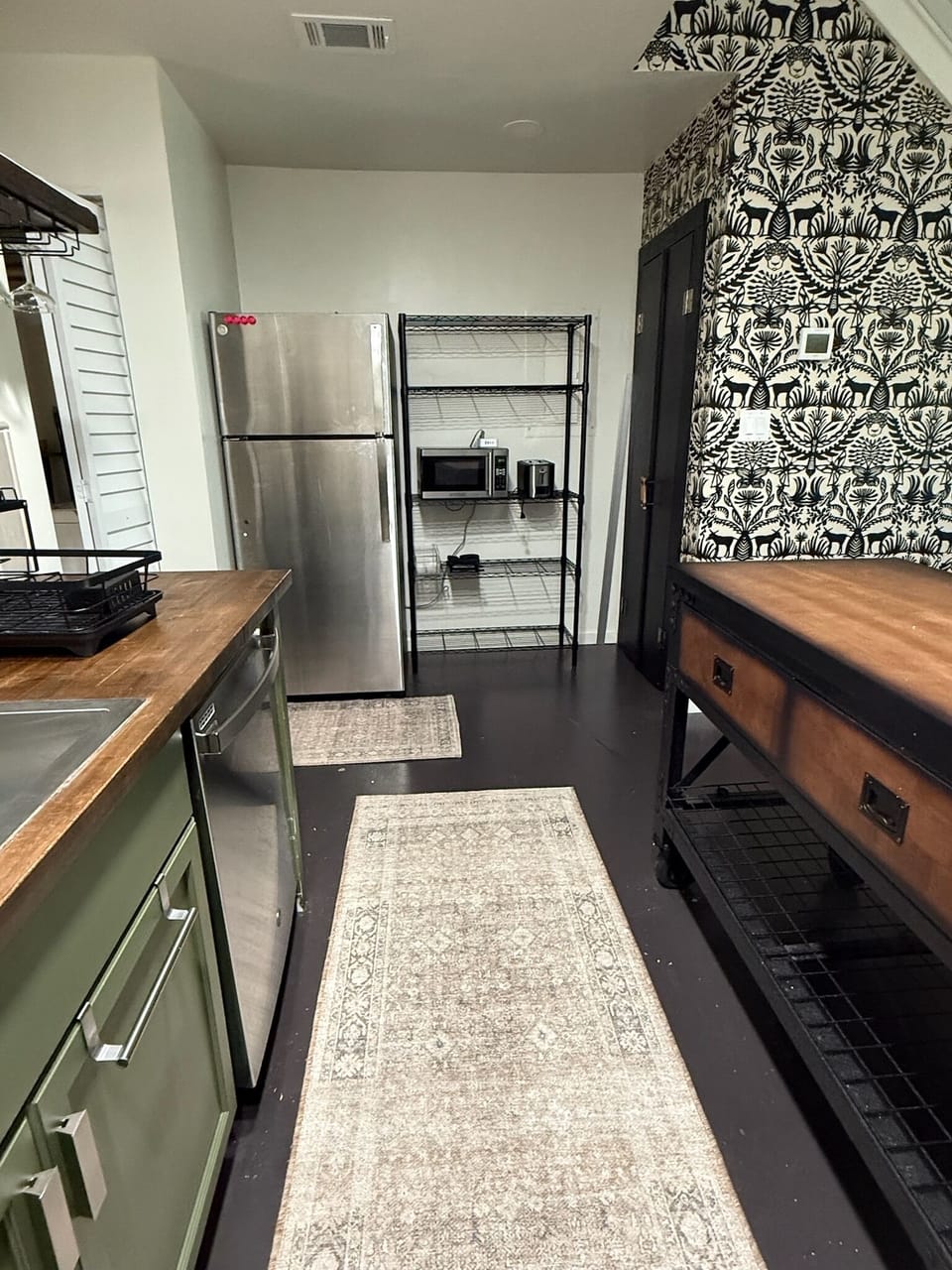 Kitchen - showing fridge and shelving unit with microwave and toaster.