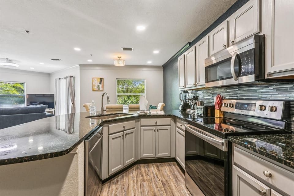 - Open concept kitchen with bar counter and modern design  
- Overlooks dining and living area for seamless connection  
- Ideal setup for hosting meals and enjoying family time