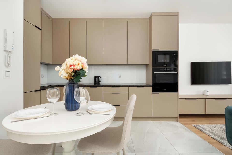 A sleek, fully-equipped kitchen comes with modern appliances, ample storage, and a charming dining area ideal for enjoying meals at home.