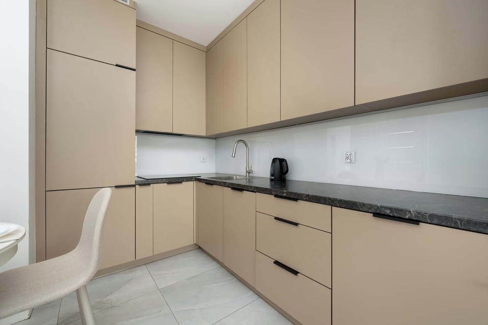 A sleek, fully-equipped kitchen comes with modern appliances, ample storage, and a charming dining area ideal for enjoying meals at home.