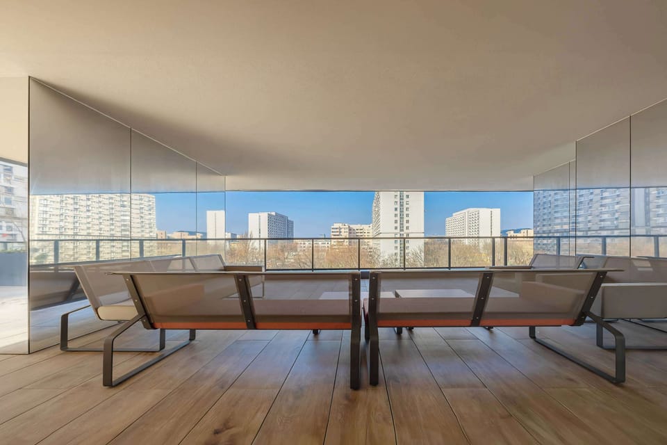 Another shared terrace space with stylish chairs and tables under cover. Great for enjoying time outside in any weather.
