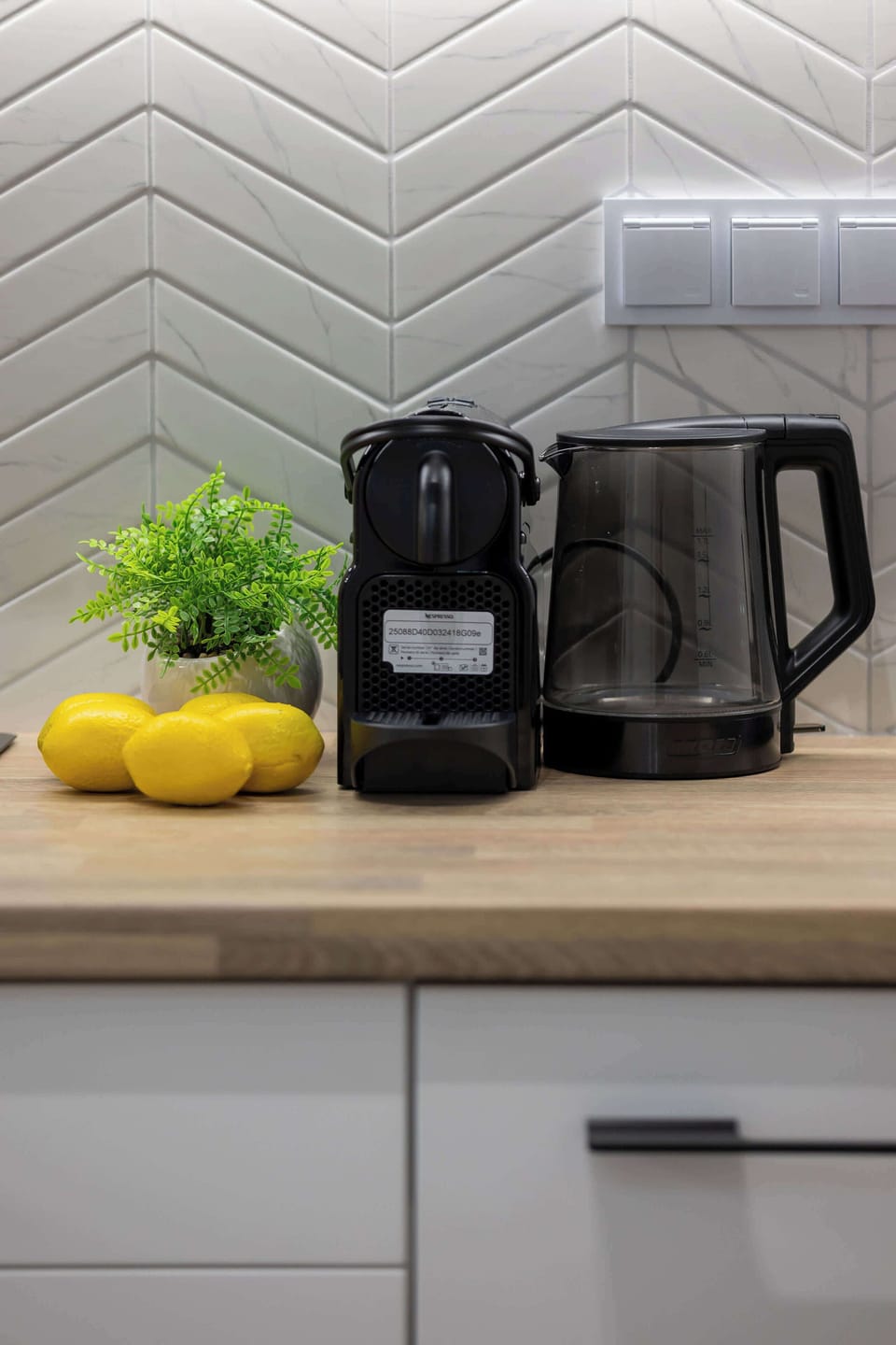 A compact coffee station with a capsule machine and mugs ready for use. Ideal for starting the day with a fresh brew.