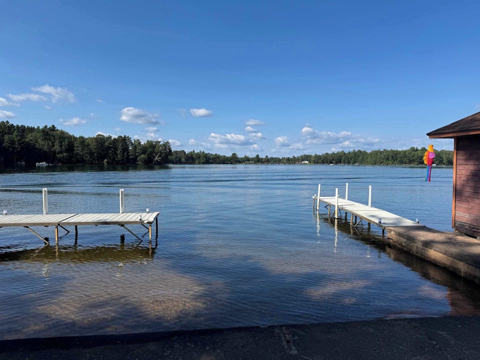 View from private boat docks (able to support 3-4 boats depending on size) and private swimming area along 500+ feet of sandy beach and lakeshore.  The boat docs form a protective shallow swim area great for young kids. 