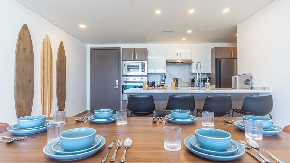 The dining table and seats at the kitchen counter.