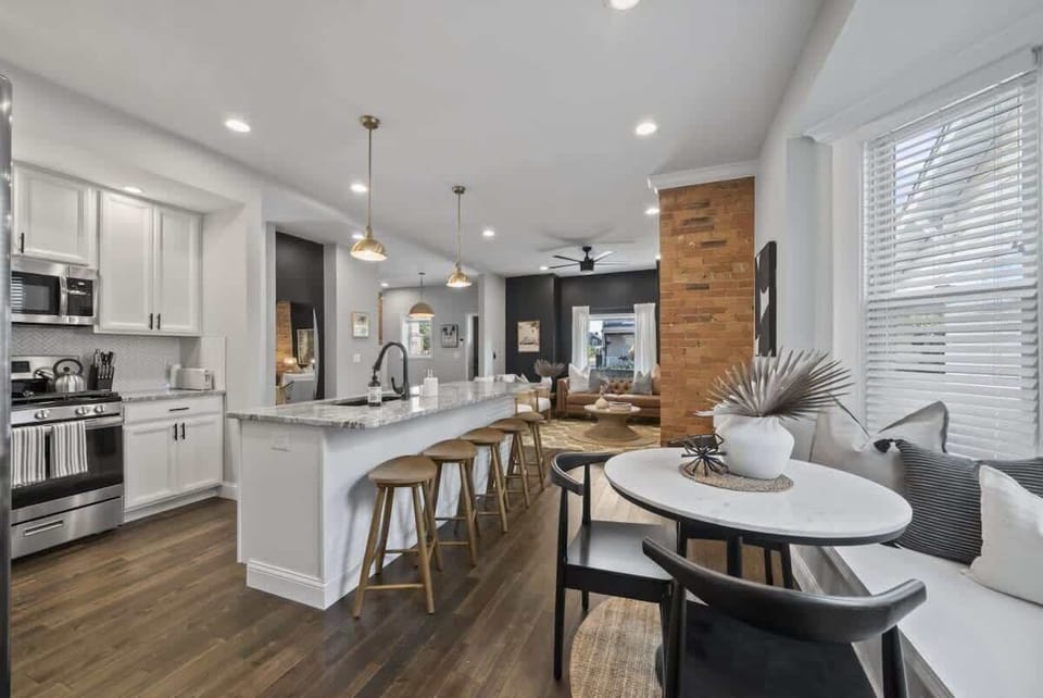 Bright open kitchen w/ large island seating, modern appliances, & space for gathering