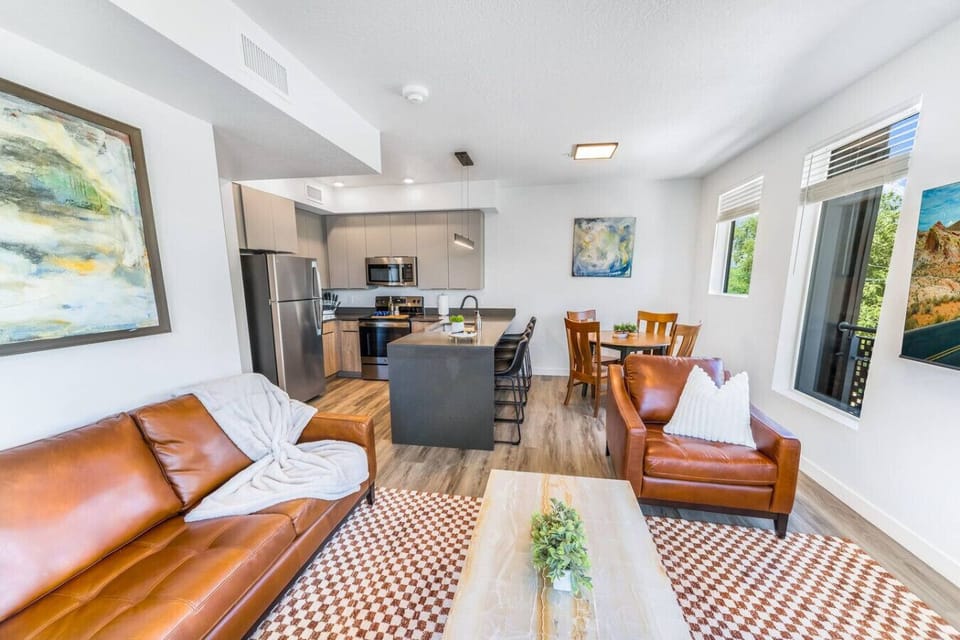 Beautifully designed living room. 75` TV, leather sofa and amazing views of mountains and city skyline.