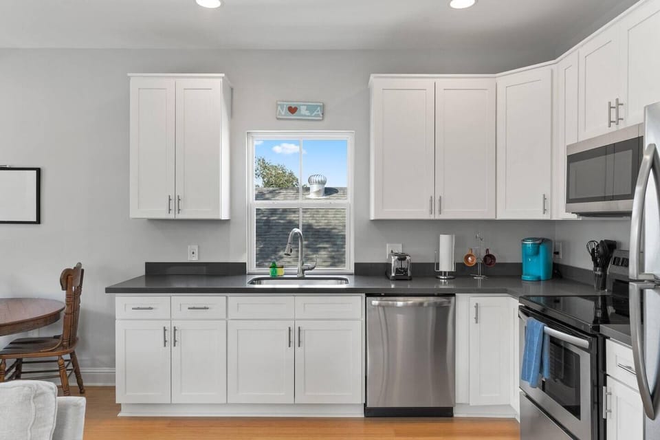 Bright kitchen w/ dark countertops & everything you need for home-cooked meals.
