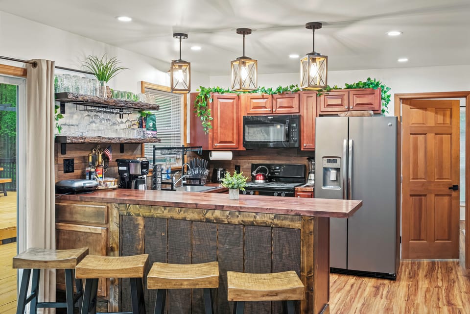Warm wooden stools line the rustic wooden kitchen counter.