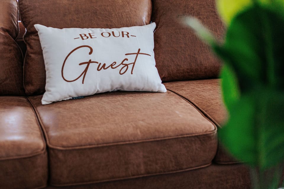 Inviting leather sofas adorned with a soft throw pillow welcome guests to relax in the stylish common area.