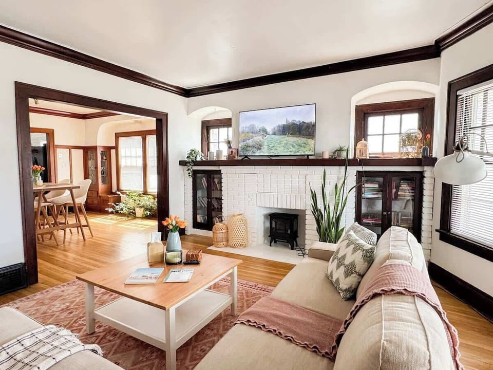 Comfy sectional sofa with a 55” TV, faux fireplace and original 100 years old built-in cabinets.