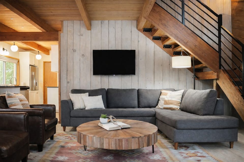 Sink into this plush sectional sofa where exposed beams and modern comfort create your perfect retreat for unwinding after mountain adventures.