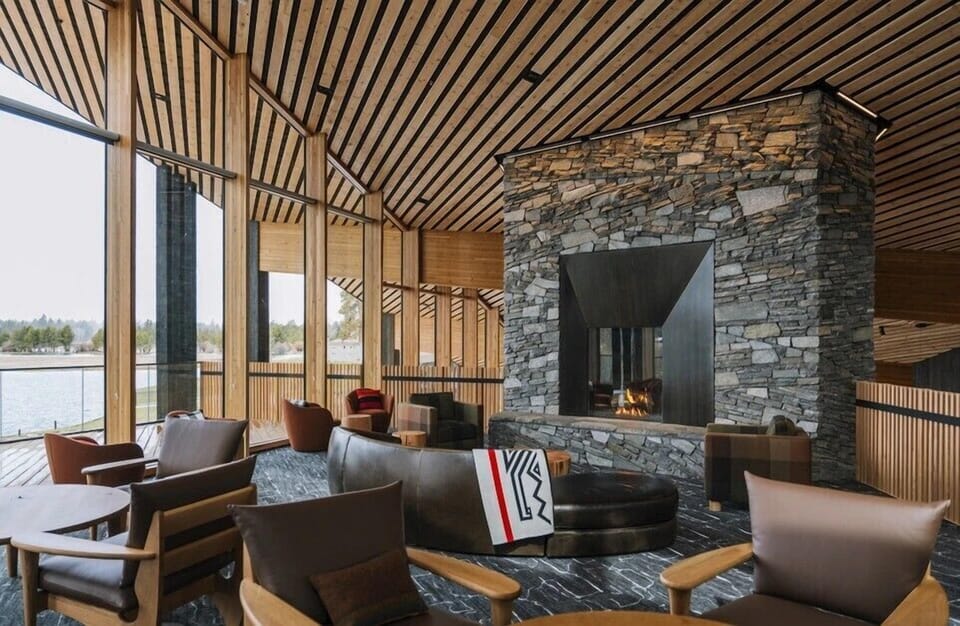 Sink into luxurious leather seating beside the stone fireplace, where warm wood beams create your perfect lakeside retreat.