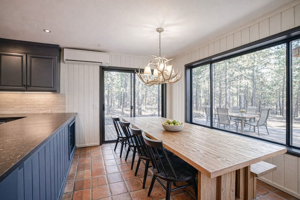 Gather around this handcrafted table where morning coffee meets rustic elegance, with forest views creating your perfect breakfast backdrop.