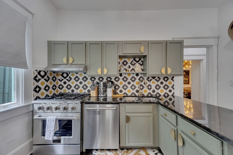 Bright kitchen w/ ample cabinetry, detailed backsplash & stainless finishes